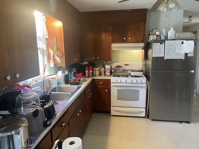 kitchen with sink, ceiling fan, white range with gas stovetop, and stainless steel refrigerator