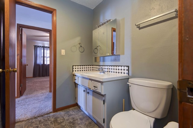 bathroom featuring vanity, toilet, and a textured ceiling