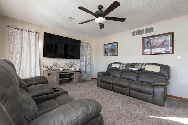 living room featuring carpet flooring, ceiling fan, and a textured ceiling