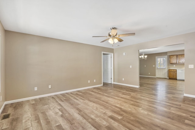 empty room with ceiling fan with notable chandelier and light hardwood / wood-style floors