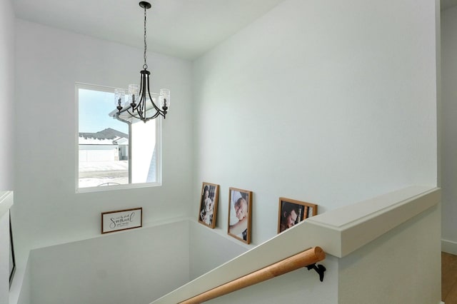 staircase featuring a healthy amount of sunlight and a notable chandelier