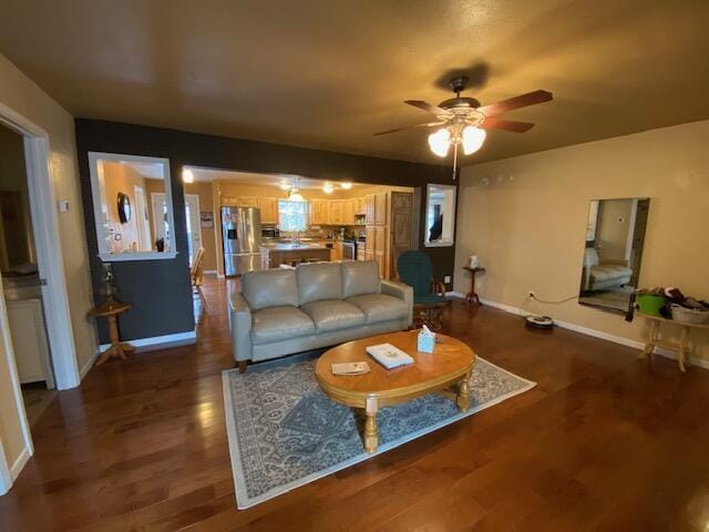 living room with ceiling fan and dark hardwood / wood-style flooring