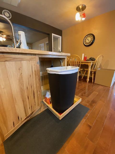 bar with light brown cabinets and hardwood / wood-style flooring