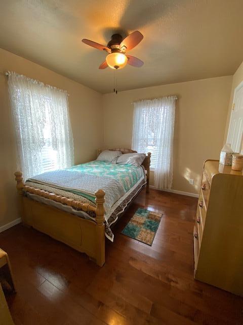 bedroom with ceiling fan and dark wood-type flooring