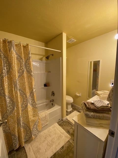 full bathroom featuring shower / bath combo with shower curtain, vanity, and toilet