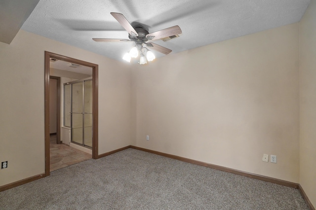 carpeted empty room featuring ceiling fan and a textured ceiling