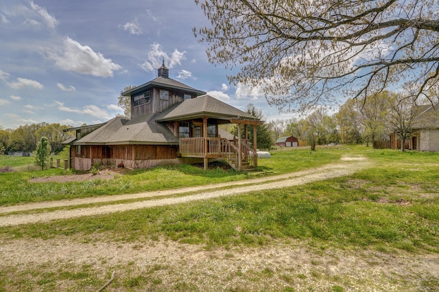 rear view of house featuring a porch and a yard