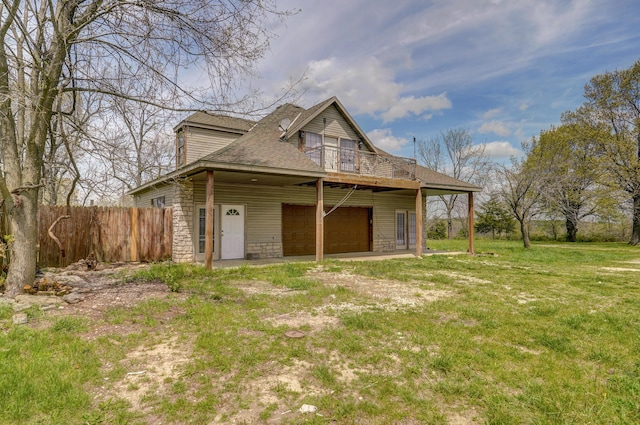 back of house featuring a lawn and a garage