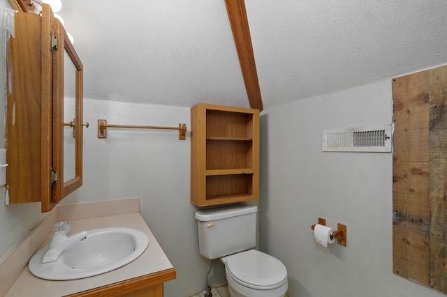 bathroom with vanity, lofted ceiling, and toilet