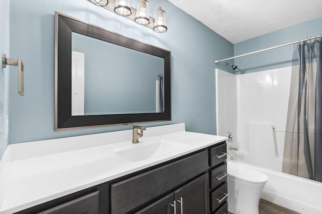 full bathroom featuring vanity, hardwood / wood-style flooring, toilet, shower / bath combo with shower curtain, and a textured ceiling