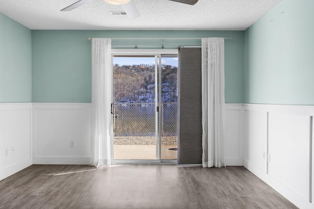 spare room featuring hardwood / wood-style flooring, ceiling fan, and a textured ceiling