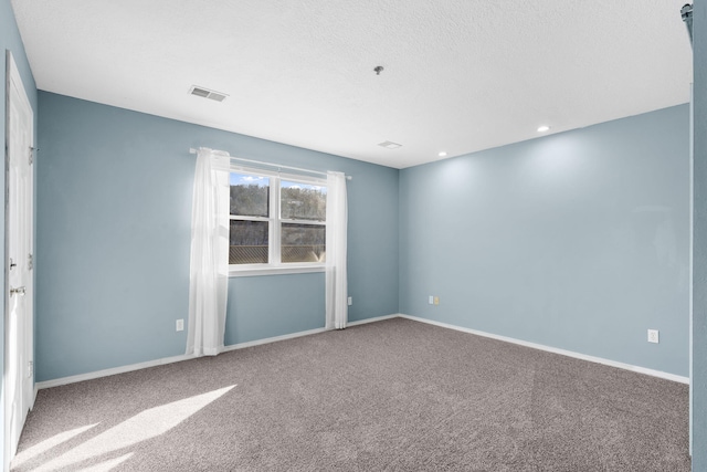 carpeted spare room with a textured ceiling