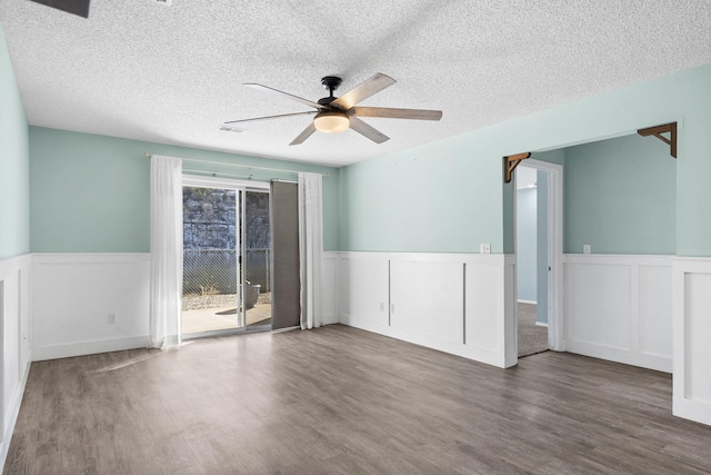 spare room with a textured ceiling, dark hardwood / wood-style flooring, and ceiling fan