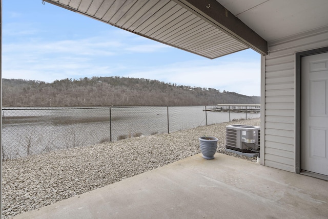 view of patio with a water view and central AC unit