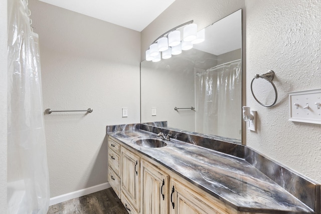 bathroom featuring walk in shower, vanity, and hardwood / wood-style flooring