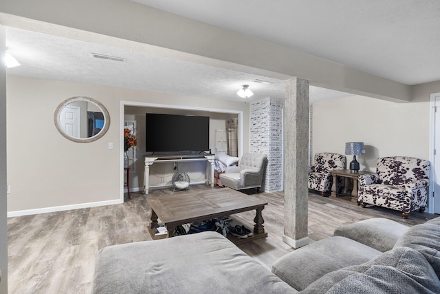 living room with a textured ceiling and wood-type flooring