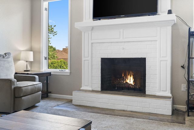 living room featuring a brick fireplace and carpet floors