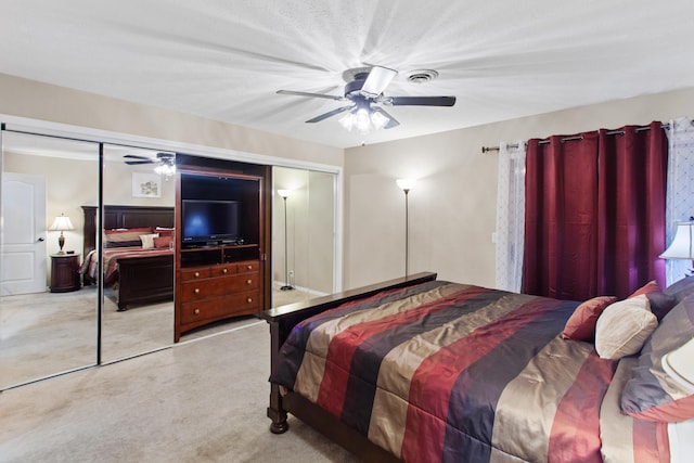 bedroom featuring ceiling fan, light colored carpet, and a closet