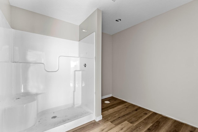 bathroom with a shower and wood-type flooring