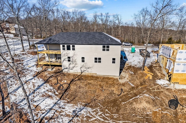 view of snow covered back of property