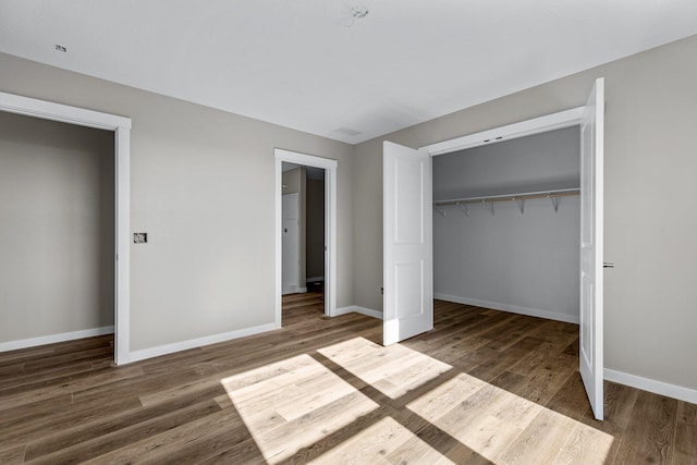 unfurnished bedroom featuring dark wood-type flooring and a closet