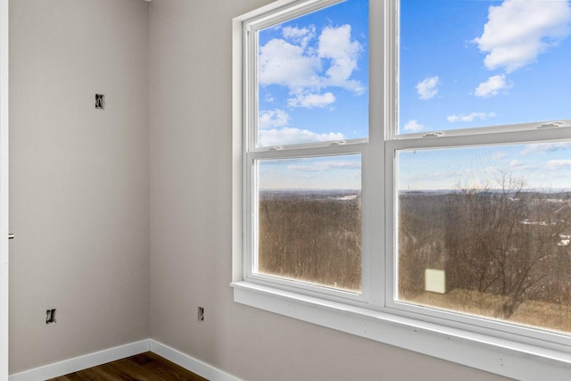 empty room with a healthy amount of sunlight and dark hardwood / wood-style floors