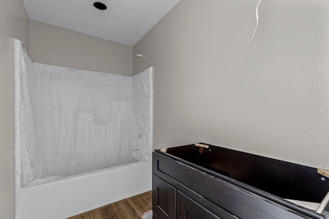 bathroom with shower / bathtub combination and hardwood / wood-style floors