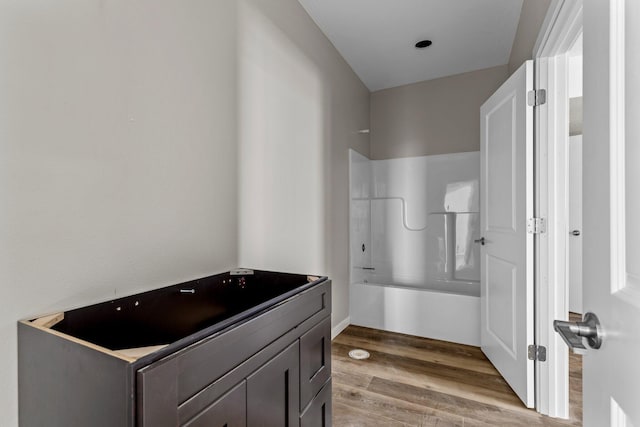 bathroom featuring vanity, shower / washtub combination, and hardwood / wood-style floors