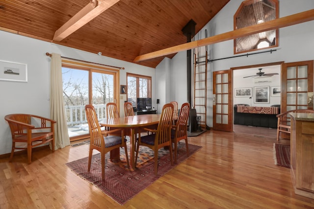 dining room featuring beam ceiling, light wood-type flooring, high vaulted ceiling, and french doors