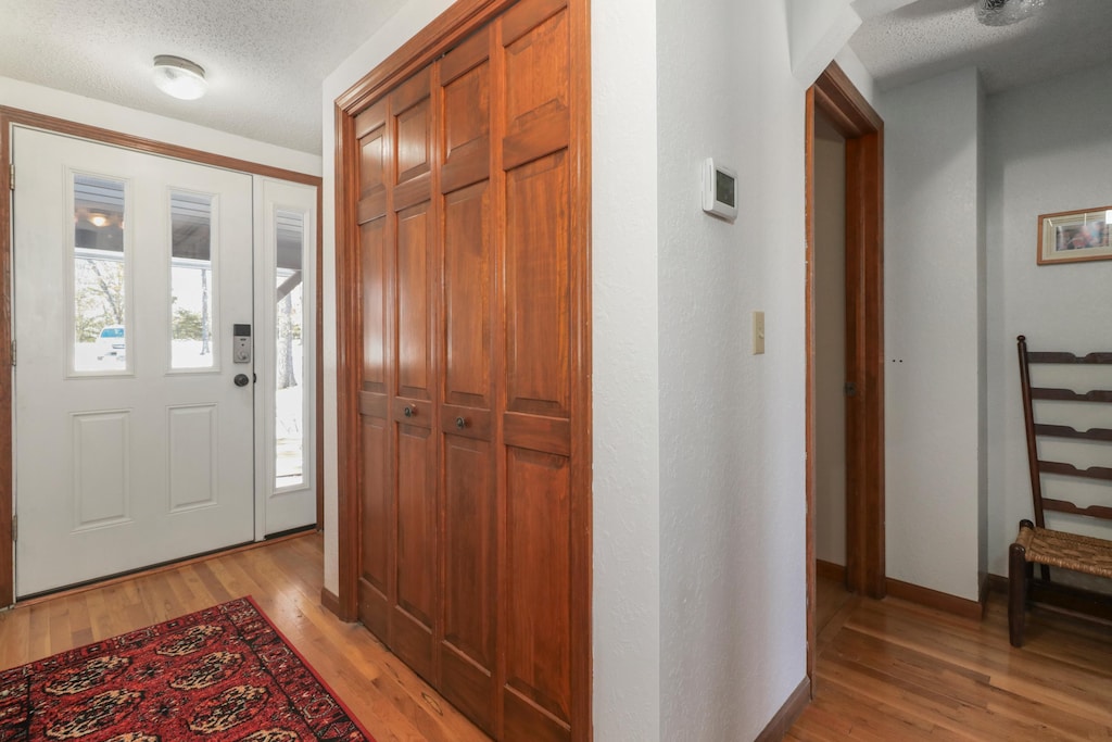 foyer featuring a textured ceiling and light wood-type flooring