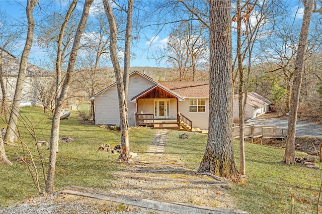 view of front of home with a deck and a front lawn