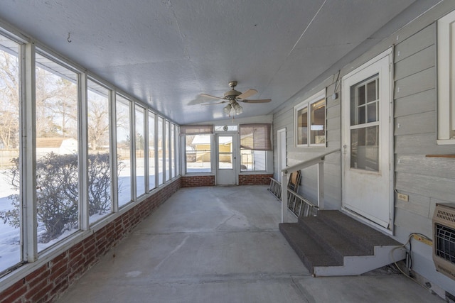 unfurnished sunroom featuring ceiling fan and heating unit