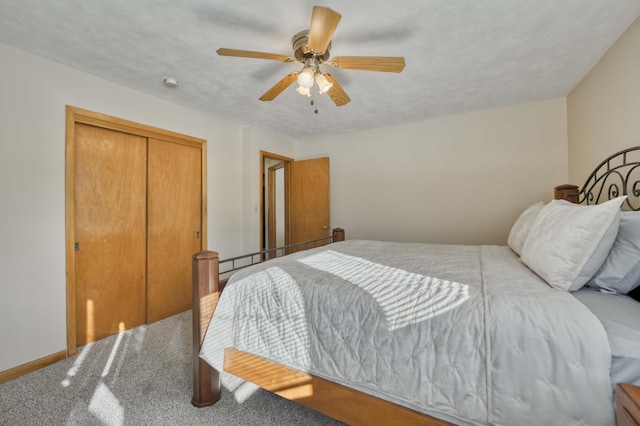 bedroom featuring a closet, a textured ceiling, ceiling fan, and carpet flooring