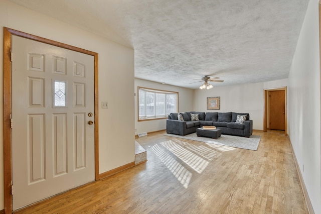 foyer entrance with ceiling fan and light hardwood / wood-style floors