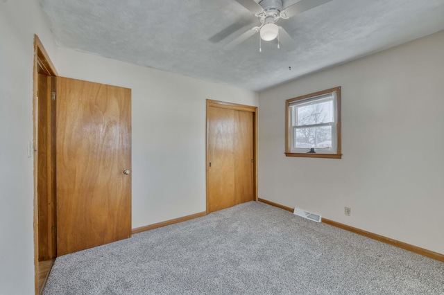 unfurnished bedroom featuring carpet floors, ceiling fan, and a closet