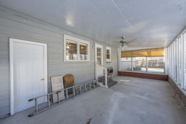 unfurnished sunroom with ceiling fan