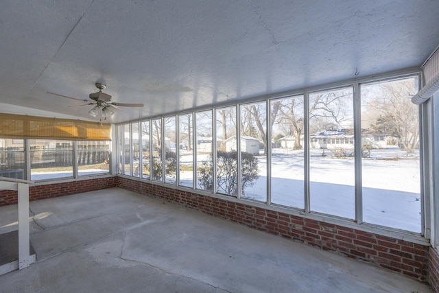 unfurnished sunroom featuring ceiling fan and plenty of natural light