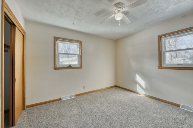 unfurnished bedroom featuring a closet, carpet floors, and ceiling fan