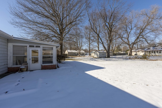 yard covered in snow featuring a storage shed