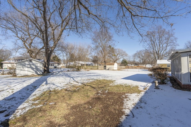 yard layered in snow featuring a storage shed