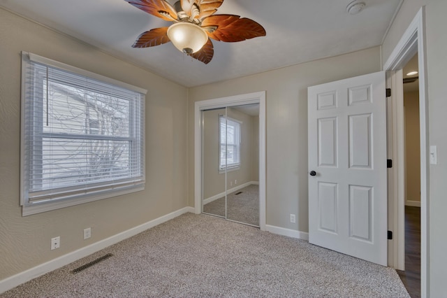 unfurnished bedroom featuring ceiling fan, a closet, and carpet