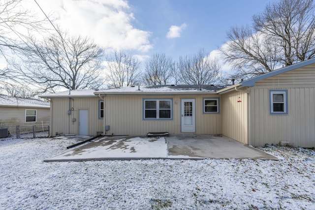 snow covered rear of property featuring a patio and central air condition unit