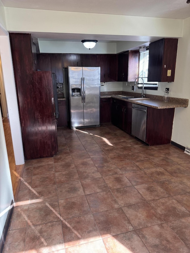 kitchen featuring stainless steel appliances, sink, and dark brown cabinetry