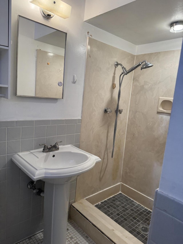 bathroom with tile walls, tile patterned flooring, and a tile shower