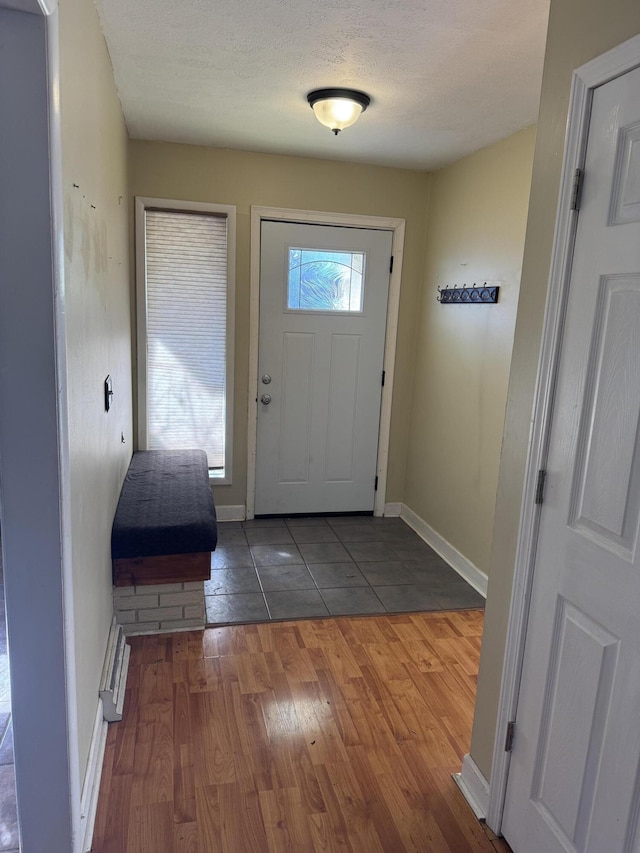 doorway with dark wood-type flooring and a textured ceiling