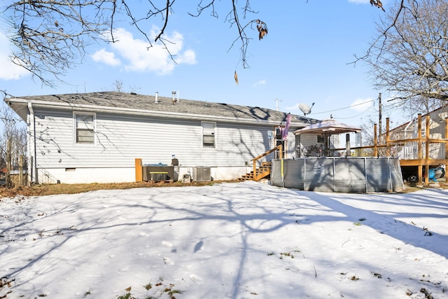 snow covered back of property with cooling unit