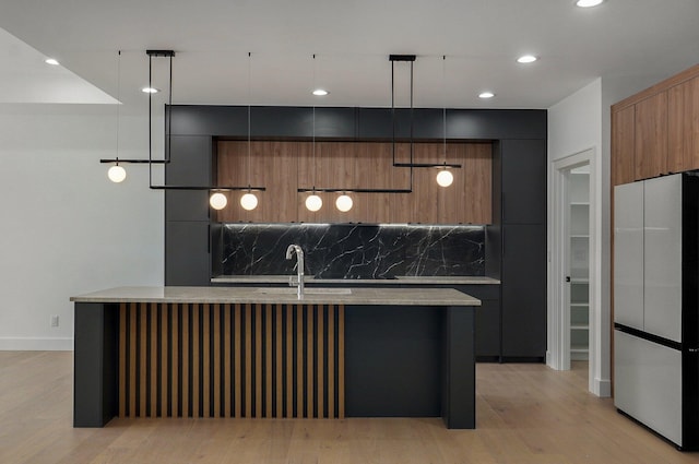 kitchen with pendant lighting, fridge, a center island, and decorative backsplash