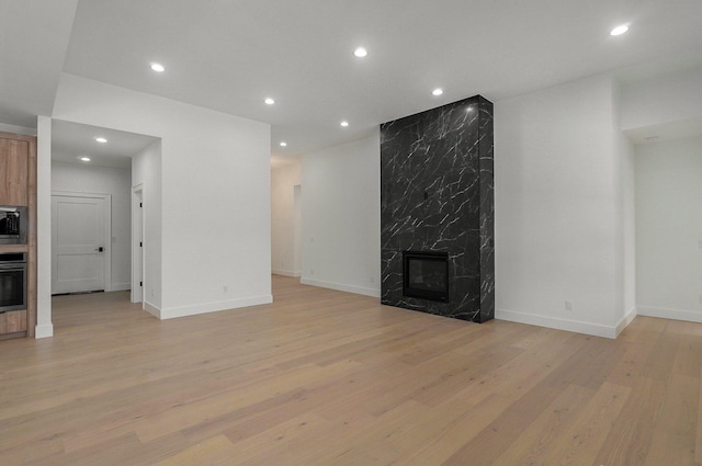 unfurnished living room with a premium fireplace and light wood-type flooring