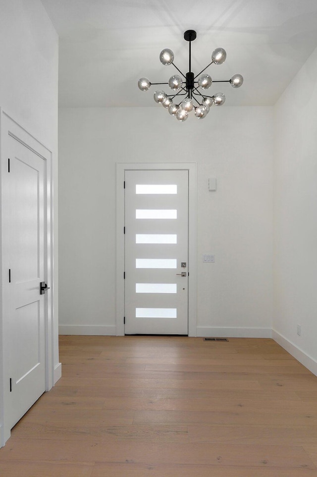 foyer featuring light hardwood / wood-style flooring and a chandelier