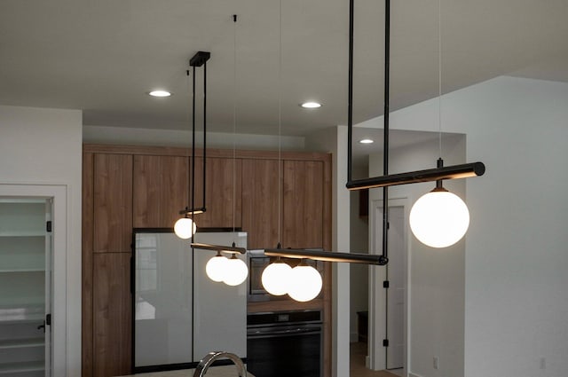 details featuring black oven and hanging light fixtures